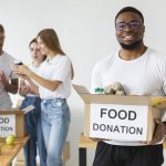 smiley-male-volunteer-holding-food-donations